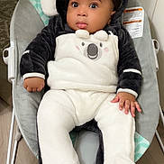 Ebubechukwu is registered to the contest to win money with this photo: baby, infant, onesie, koala, baby_rocker, cushion, floor, wooden_floor, clothing, child, indoors, cute, black_and_white, soft_texture, footwear, hand, face, portrait, seat, expression