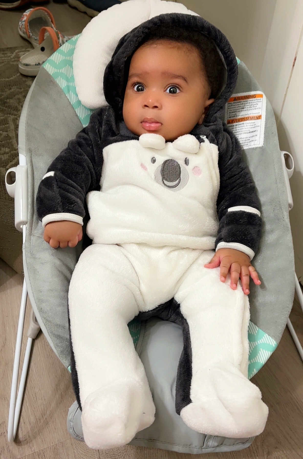 Ebubechukwu is registered to the contest to win money with this photo: baby, infant, onesie, koala, baby_rocker, cushion, floor, wooden_floor, clothing, child, indoors, cute, black_and_white, soft_texture, footwear, hand, face, portrait, seat, expression