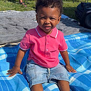 Kordero joined the competition — help win amazing prizes! toddler, child, boy, outdoor, blanket, blue, pink_shirt, denim_shorts, grass, sunlight, shoes, person, sitting, summer, casual_clothing, portrait, expression, nature, chair, relaxation