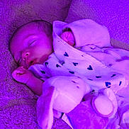 Mylo a rejoint le concours — aidez-le/la à gagner de superbes lots ! baby, sleeping, blanket, plush_toy, bunny, purple_light, cozy, infant, soft_texture, cute, peaceful, child, wrapped, resting, indoor, warm, toddler, face, person, comfort