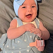 Salem is registered to the contest to win money with this photo: baby, smiling, blue_bow, headband, dress, infant, happy, hands, lying_down, patterned_clothing, cute, cheerful, close_up, human, skin, indoors, child, adorable, baby_accessory, infant_fashion