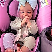 Salem is registered to the contest to win money with this photo: baby, bow, car_seat, child, close_up, clothing, cute, feet, hands, happy, headband, indoors, infant, infant_clothing, pacifier, pink, portrait, seat_belt, smiling, soft_toys