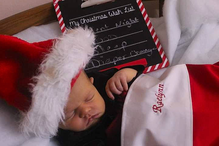 Raelynn is registered to the contest to win money with this photo: carmine, christmas, christmas_eve, christmas_stocking, costume_hat, event, fur, fur_clothing, gesture, hat, headwear, holiday, lap, outerwear, person, room, santa_claus, sleeve, t_shirt, textile