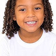 Seven joined the competition — help win amazing prizes! child, portrait, smiling, happy, curly_hair, face, teeth, eyes, white_shirt, headshot, indoors, photograph, closeup, looking_at_camera, young_person, natural_hair, brown_skin, digital_screen, phone_interface, black_background