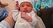 Deonte joined the competition — help win amazing prizes! baby, newborn, infant, hat, clothing, hand, blanket, carpet, floor, person, cute, indoors, child, sleepwear, pattern, blue, white, cartoon, holding, cozy