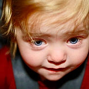 Owen is registered to the contest to win money with this photo: blonde_hair, blue_eyes, child, close_up, cute, expression, eyebrows, eyelashes, face, hair, indoors, innocence, looking_up, nostrils, person, portrait, red_clothing, skin, toddler, young