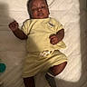 Quintavious joined the competition — help win amazing prizes! baby, baby_clothing, bedroom, child, curly_hair, face, indoor, infant, lying_down, mattress, photography, portrait, quilted_blanket, raised_hand, serious_expression, shirt, shorts, socks, soft_lighting, yellow_outfit