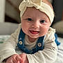 baby, infant, headband, bow, denim_overalls, smile, tongue_out, closeup, portrait, big_eyes, rosy_cheeks, hands, tummy_time, blanket, soft_light, shallow_depth_of_field, indoor, buttons, adorable, cute