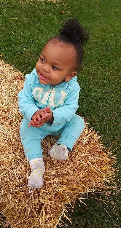 Kimora is registered to the contest to win money with this photo: agriculture, baby, baby_toddler_clothing, child, face, fun, grass, grass_family, grassland, happy, hay, people_in_nature, person, plant, sitting, sleeve, smile, soil, straw, toddler