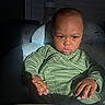 Mas is registered to the contest to win money with this photo: baby, infant, child, portrait, seated, green_outfit, striped_clothing, serious_expression, face, eyes, hands, high_chair, cushion, blanket, indoor, sunlight, shadows, furniture, photography, close_up
