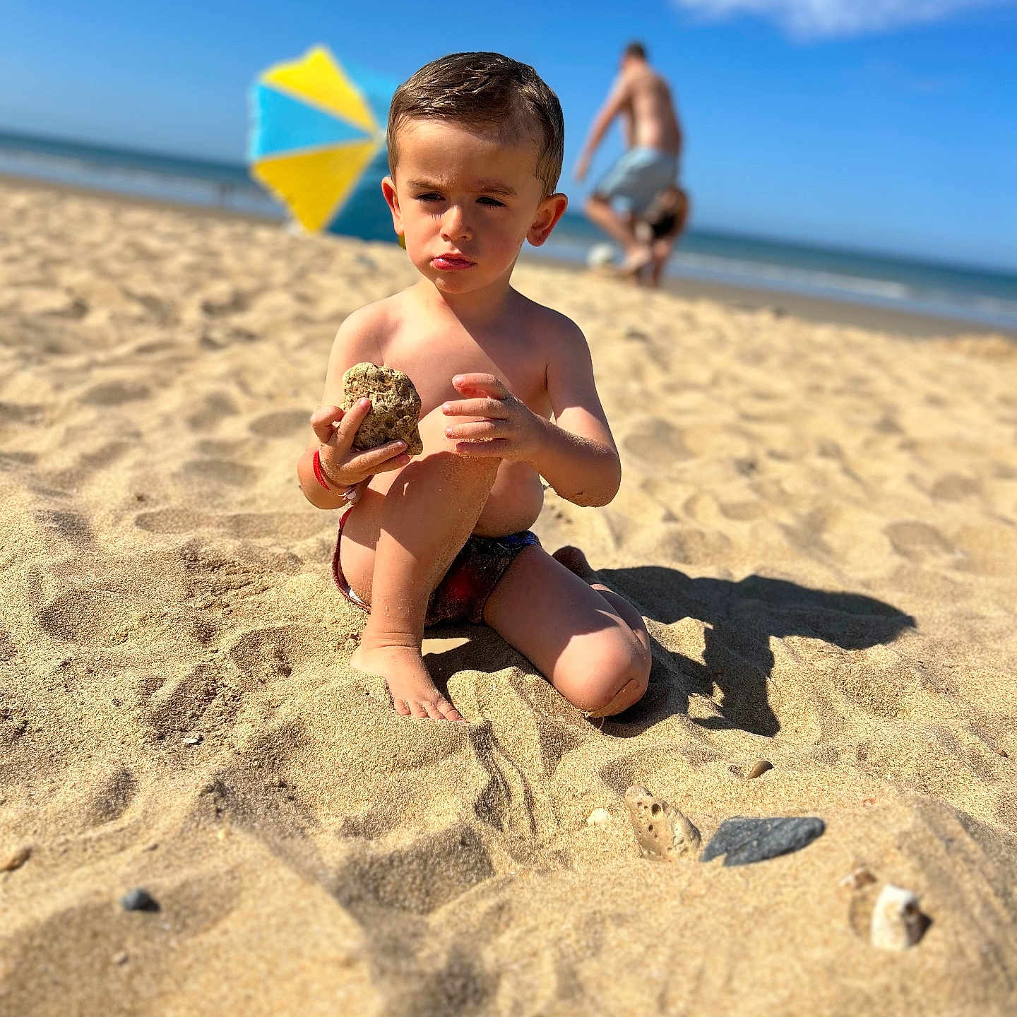 Maylonn a rejoint le concours — aidez-le/la à gagner de superbes lots ! beach, beachwear, boy, child, clothing, coast, face, head, male, nature, outdoors, person, photography, portrait, sea, shoreline, shorts, sitting, summer, water