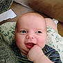 Jace is registered to the contest to win money with this photo: baby, infant, child, cheek, hand, face, smile, cushion, blanket, striped_shirt, knitwear, happy, cute, indoors, portrait, skin, young, expression, fingers, seated