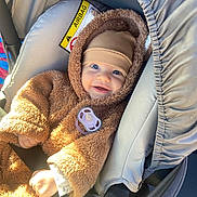 Vusal a rejoint le concours — aidez-le/la à gagner de superbes lots ! baby, child, car_seat, pacifier, brown_clothing, hat, smile, happy, infant, seatbelt, sunlight, cozy, fuzzy, cute, person, car, safety, portrait, indoor, warm