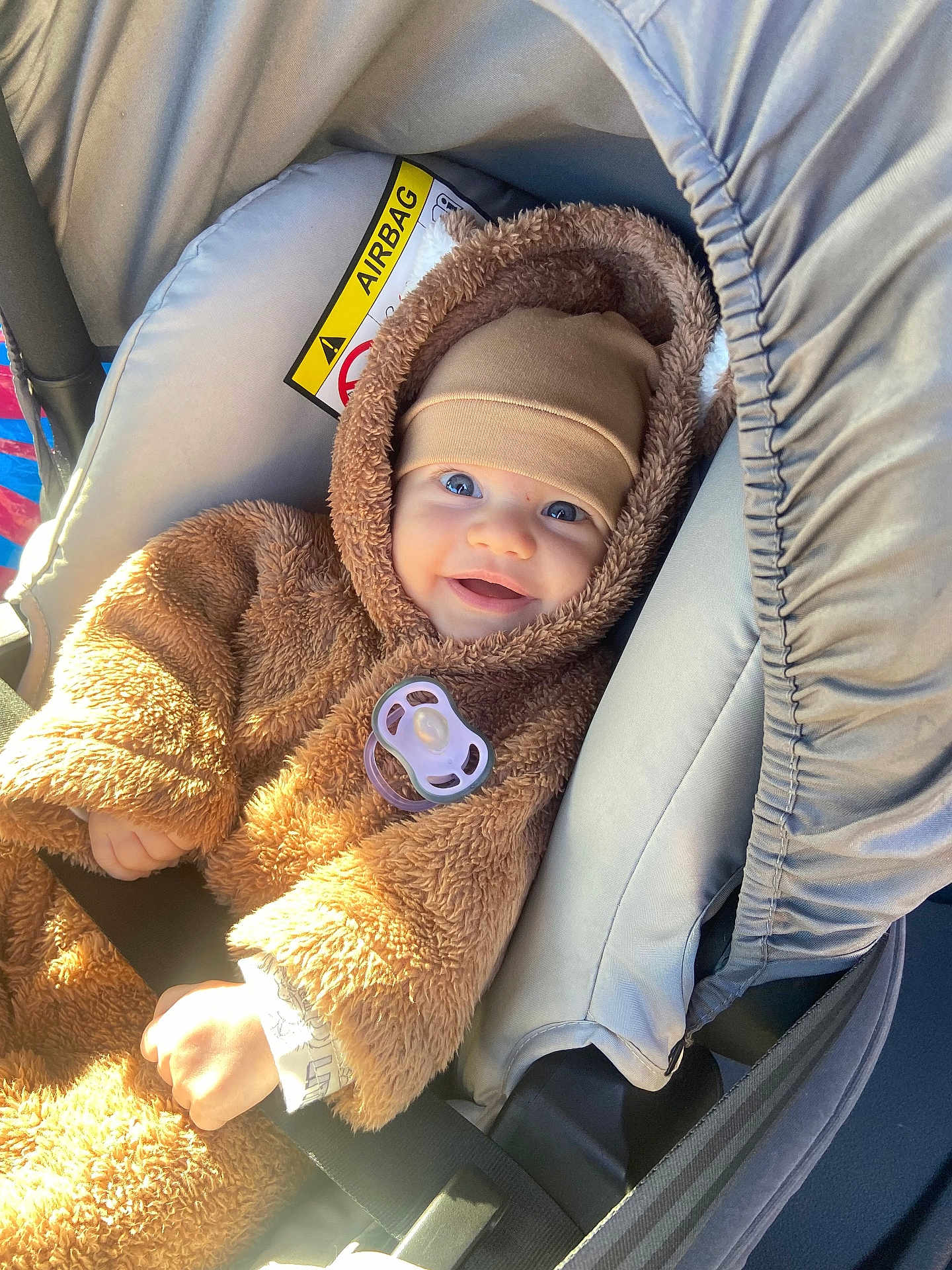 Vusal a rejoint le concours — aidez-le/la à gagner de superbes lots ! baby, child, car_seat, pacifier, brown_clothing, hat, smile, happy, infant, seatbelt, sunlight, cozy, fuzzy, cute, person, car, safety, portrait, indoor, warm