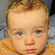 Sonny is registered to the contest to win money with this photo: toddler, child, portrait, blue_eyes, blond_hair, curly_hair, close_up, face, expression, indoor, shirt, striped_shirt, casual_clothing, young_child, curious, soft_lighting, neutral_expression, skin, person, headshot