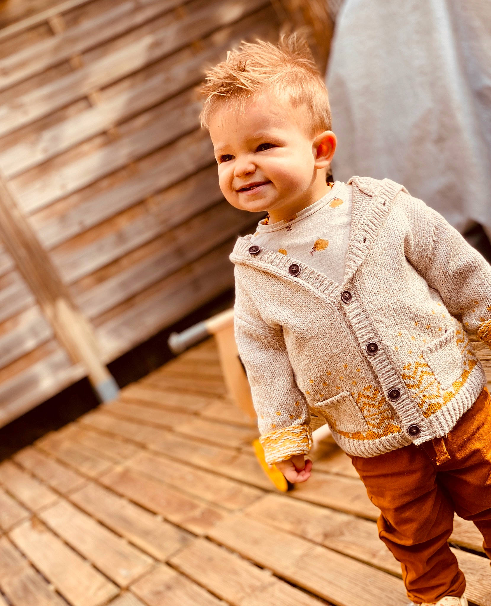Yael participe au concours pour gagner de l'argent avec cette photo : baby, cardigan, cheek, child, child_model, jacket, joy, outerwear, pattern, people, person, photograph, play, portrait_photography, sleeve, smile, sweater, toddler, top, wood