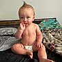 Karson joined the competition — help win amazing prizes! baby, child, diaper, bed, blanket, mohaawk, finger_in_mouth, curious, indoor, furniture, headboard, person, skin, foot, hand, expression, sitting, clutter, casual, room