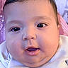 Yasmin is registered to the contest to win money with this photo: baby, infant, child, face, portrait, close_up, wide_eyes, open_mouth, short_hair, brown_hair, white_clothing, hand, bedding, blanket, indoor, bedroom, soft_lighting, pink_background, purple_tones, cute