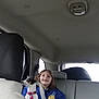 animal, backseat, car_interior, casual, child, companion, dog, happy, indoor, jacket, pet, portrait, road_trip, seatbelt, seated, smiling, tire, travel, window, young