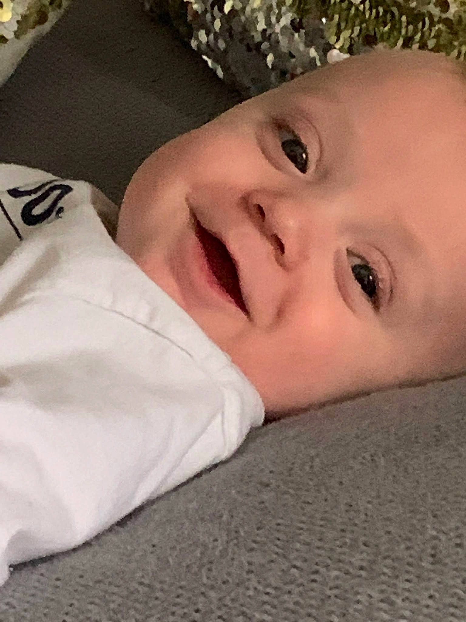 Owen is registered to the contest to win money with this photo: baby, carmine, child, comfort, eye, eyelash, flooring, fur, grass, happy, head, linens, lip, pattern, person, portrait_photography, sleeve, smile, toddler, wood