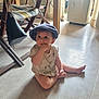 Maï-Lee participe au concours pour gagner de l'argent avec cette photo : baby, blue_cap, casual_clothing, child, curious, expression, fingers, floor, hat, home, indoor, legs, natural_light, open_door, person, purse, room, sitting, toddler, wooden_chair