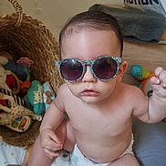 Maï-Lee a rejoint le concours — aidez-le/la à gagner de superbes lots ! baby, basket, casual, child, colorful, cute, diaper, drool, expression, floor, indoor, infant, person, play_area, plush_toy, portrait, stuffed_animal, sunglasses, toy, wooden_floor