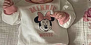 Jersey is registered to the contest to win money with this photo: baby, bow, child, clothing, cozy, cute, floral_blanket, happy, headband, indoors, infant, lying_down, minnie_mouse, person, pink_pants, playful, portrait, smiling, sweater, tongue_out