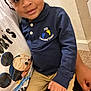 Gregory joined the competition — help win amazing prizes! toddler, child, person, smiling, indoor, polo_shirt, navy_blue, logo, hand, mickey_mouse, tshirt, beige_wall, carpet, sitting, cute, young_child, face, eyes, happy, casual_clothing