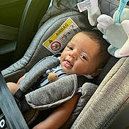 Naïm a rejoint le concours — aidez-le/la à gagner de superbes lots ! baby, car_seat, child, smile, infant, seat_belt, toy, safety_warning, cute, comfort, clothing, head, face, indoor, person, young_child, leisure, seat, strapped, portrait