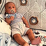 baby, pacifier, blanket, crochet, pattern, animal_print, infant, clothing, comfort, cute, child, toddler, indoors, soft_toys, relaxed, foot, hand, person, portrait, resting