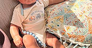 Noah is registered to the contest to win money with this photo: baby, infant, couch, pillow, sunlight, toy, beads, clothing, face, skin, hand, foot, comfort, indoor, texture, pattern, relaxation, child, person, home