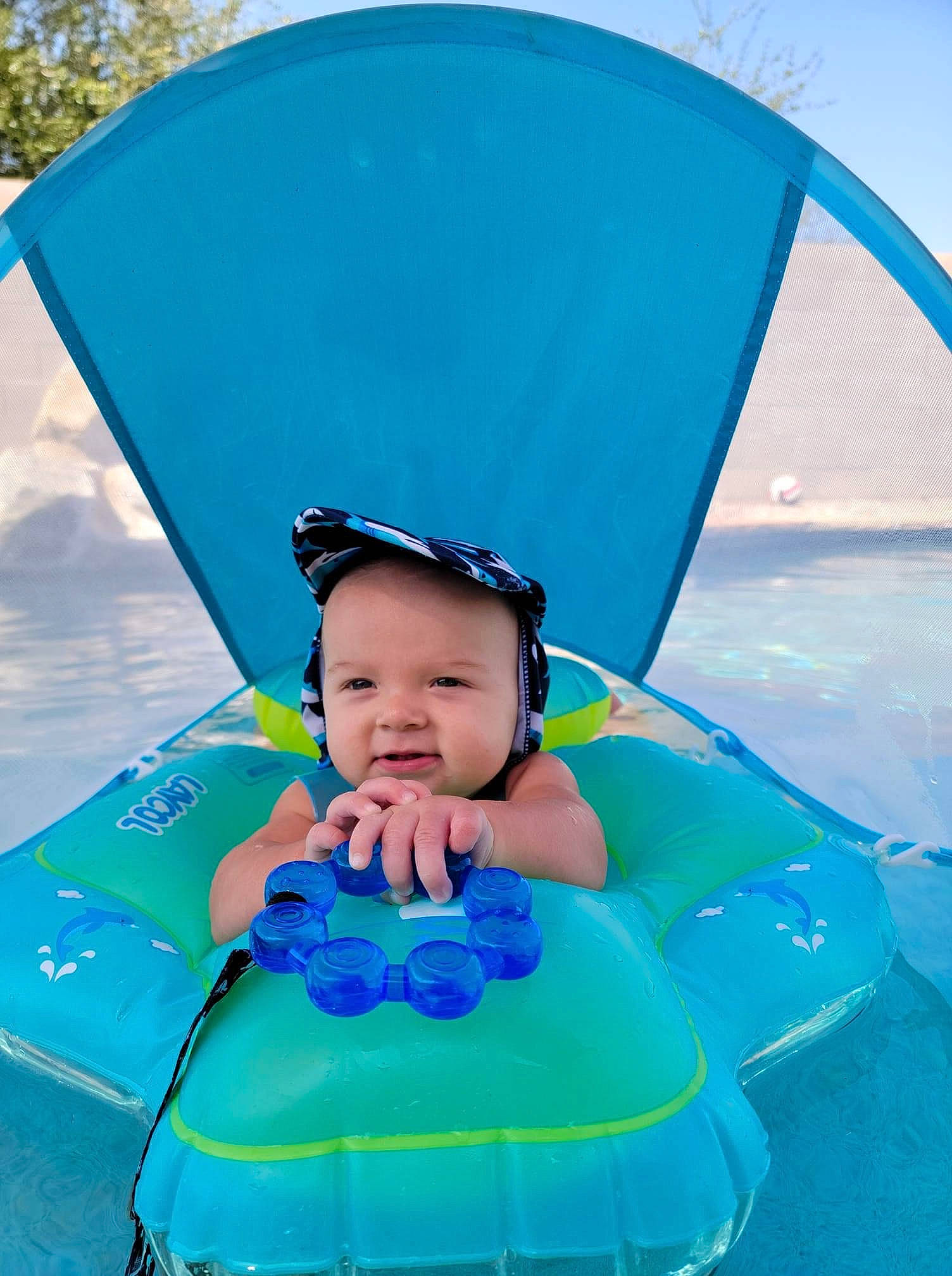 Colt is registered to the contest to win money with this photo: aqua, azure, baby, baby_products, baby_toddler_clothing, blue, child, electric_blue, facial_expression, fashion_accessory, fun, happy, headwear, leisure, person, personal_protective_equipment, photograph, recreation, smile, snapshot