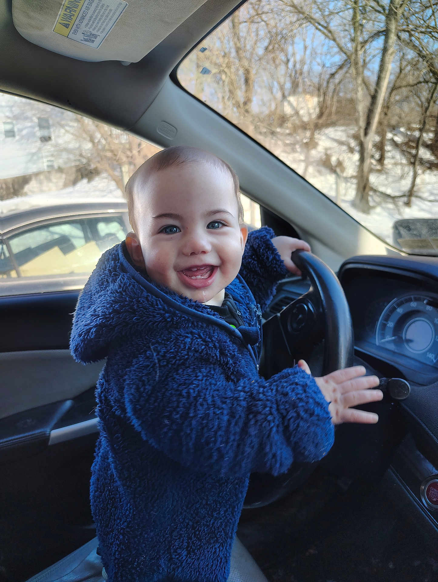 Stanley Cash joined the competition — help win amazing prizes! toddler, child, smiling, blue_jacket, car_interior, steering_wheel, happy, winter, snow, window, seat, dashboard, clothing, person, face, hand, vehicle, daylight, head, indoors
