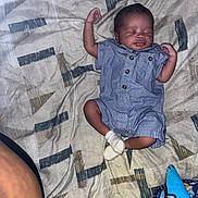 Mikhailo is registered to the contest to win money with this photo: baby, infant, sleeping, blue_clothing, romper, white_socks, blanket, patterned_blanket, plush_toy, colorful_toy, person, arm, sleep, indoors, rest, child, cute, peaceful, young, lying_down