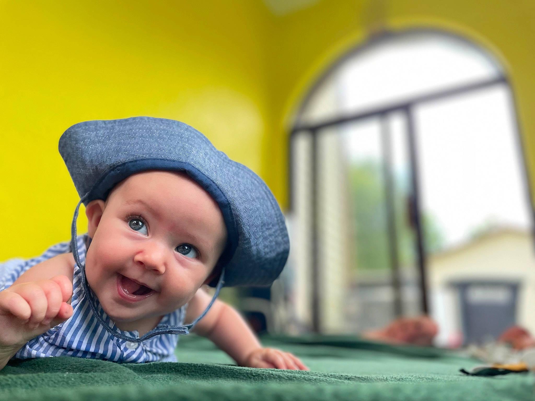 Octavia is registered to the contest to win money with this photo: baby, baby_toddler_clothing, cap, child, fashion_accessory, flash_photography, fun, grass, happy, hat, headwear, leisure, person, play, recreation, sitting, skin, smile, sun_hat, toddler