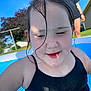 child, swimming_pool, water, wet_hair, black_swimsuit, outdoor, summer, sunny, backyard, person, grass, house, tree, blue_sky, recreation, play, fun, happy, childhood, leisure