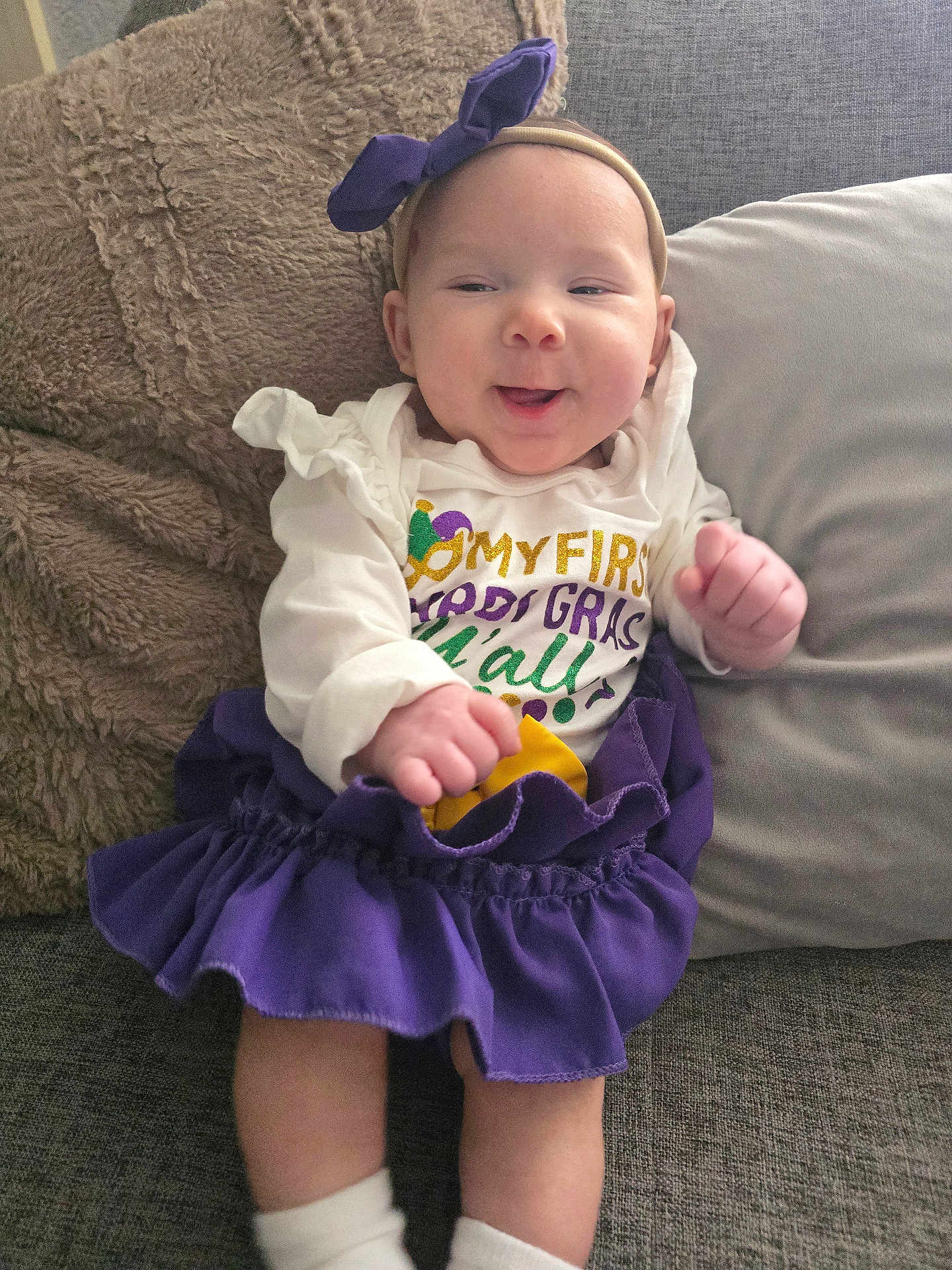 Gioella joined the competition — help win amazing prizes! baby, infant, smiling, headband, bow, purple_skirt, ruffle_skirt, onesie, couch, pillow, blanket, cozy, hands, legs, socks, portrait, cute, home_interior, happy, baby_clothing