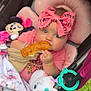 baby, stroller, bow, bread, plush_toy, unicorn, minnie_mouse, blanket, pink, blue_eyes, outdoor, grass, cute, infant, child, bracelet, toy, snack, cozy, headband