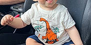 Ryder joined the competition — help win amazing prizes! baby, child, dinosaur_shirt, blue_eyes, car_seat, smiling, barefoot, shorts, infant, cute, happy, sitting, person, casual_clothing, indoor, light_skin, short_hair, cute_expression, human, family