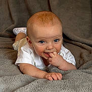 Ryder joined the competition — help win amazing prizes! baby, infant, child, blanket, soft_texture, white_clothing, blue_eyes, hand_in_mouth, crawling, cute, portrait, indoor, skin, fingers, smiling, happy, lying_down, toddler, cozy, closeup