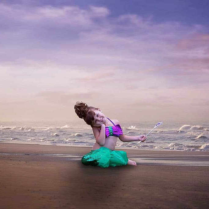 Gianna is registered to the contest to win money with this photo: beach, child, clothing, coast, face, head, nature, outdoors, person, photography, portrait, purple, sea, shoreline, skirt, sky, soil, summer, swimwear, water