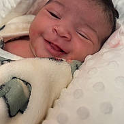 Ilanna is registered to the contest to win money with this photo: baby, smiling, blanket, pillow, cozy, infant, face, child, soft, texture, happy, portrait, cute, newborn, resting, comfort, warm, closeup, sleepy, indoors