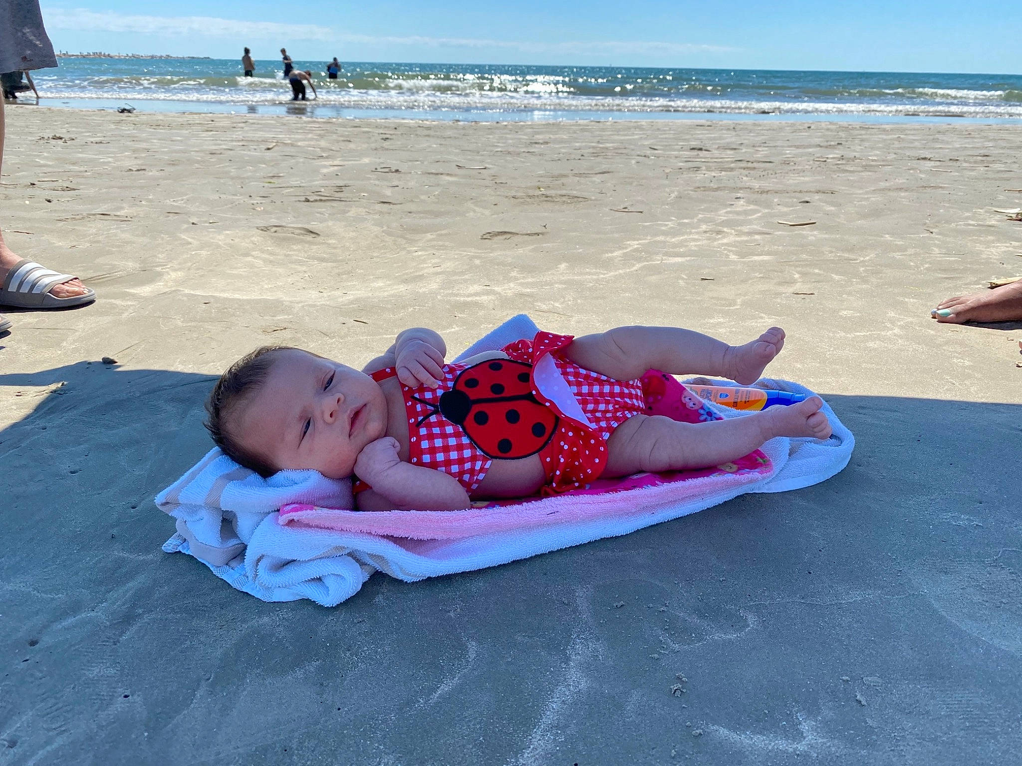 Julissa is registered to the contest to win money with this photo: baby, beach, comfort, foot, fun, happy, holiday, horizon, leisure, outdoor_furniture, people_in_nature, people_on_beach, person, recreation, shorts, sitting, sky, sun_tanning, toddler, travel