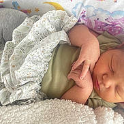 Alannah is registered to the contest to win money with this photo: baby, sleeping, infant, blanket, headband, clothing, hand, face, soft_texture, bed, bedding, pattern, stars, moon, cute, peaceful, newborn, resting, child, cozy