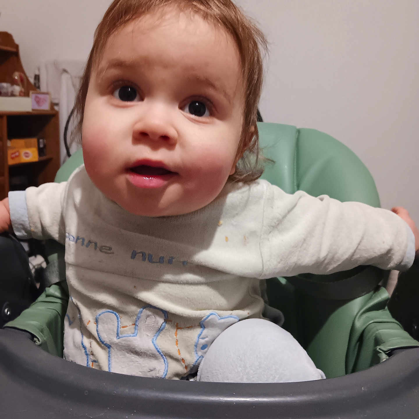 Djebryl participe au concours pour gagner de l'argent avec cette photo : blue_design, brown_hair, child, clothing, curious, expression, face, furniture, high_chair, home, indoor, person, room, seat, sitting, sleeves, toddler, tray, white_shirt, young_child