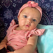 Nami joined the competition — help win amazing prizes! baby, blanket, cheeks, child, cushion, cute, eyes, face, flower, hand, headband, indoors, infant, patterned_background, person, pink_clothing, portrait, sitting, soft_texture, young