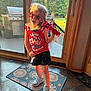 child, girl, sunglasses, red, toy, microphone, shorts, sneakers, rug, door, glass, backyard, sunlight, indoor, floor, pattern, playful, summer, casual, happy