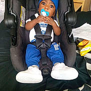 Damarion Gooden is registered to the contest to win money with this photo: child, toddler, baby, boy, car_seat, pacifier, blue_hat, blue_clothing, white_shoes, sneakers, sitting, strapped_in, wide_eyes, portrait, indoor, vehicle, car_interior, seat_belt, household_items, checkered_blanket