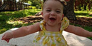 Selena joined the competition — help win amazing prizes! baby, child, smiling, outdoor, nature, tree, grass, blanket, mirror, playground, headband, yellow_clothing, happy, sitting, sunlight, park, infant, cute, summer, portrait
