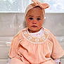 Iris participe au concours pour gagner de l'argent avec cette photo : toddler, child, baby, face, headband, peach_dress, crochet, white_couch, indoors, curious, blue_eyes, rosy_cheeks, portrait, sitting, soft_light, window, white_background, cute, fashion, young_child